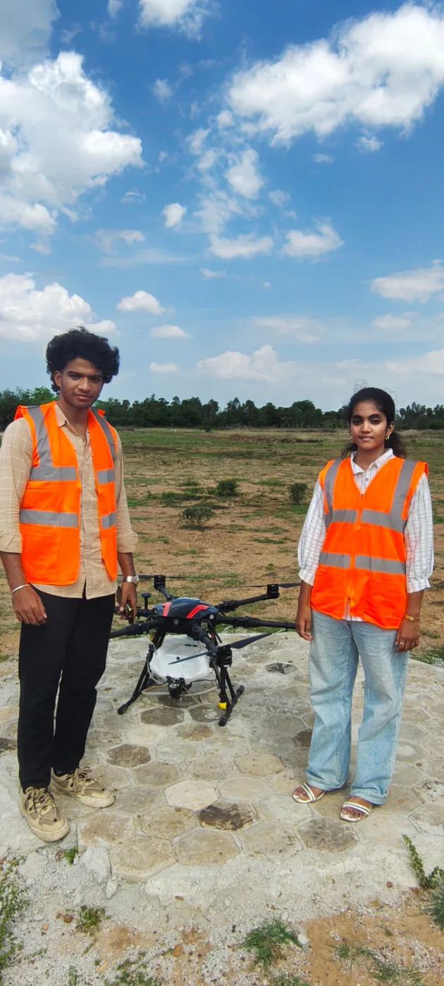 Trainees with an agri spraying drone on the flight pad at the AerobotLabs campus